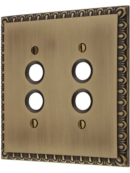 Ovolo Double Gang Push-Button Switch Plate in Antique Brass.